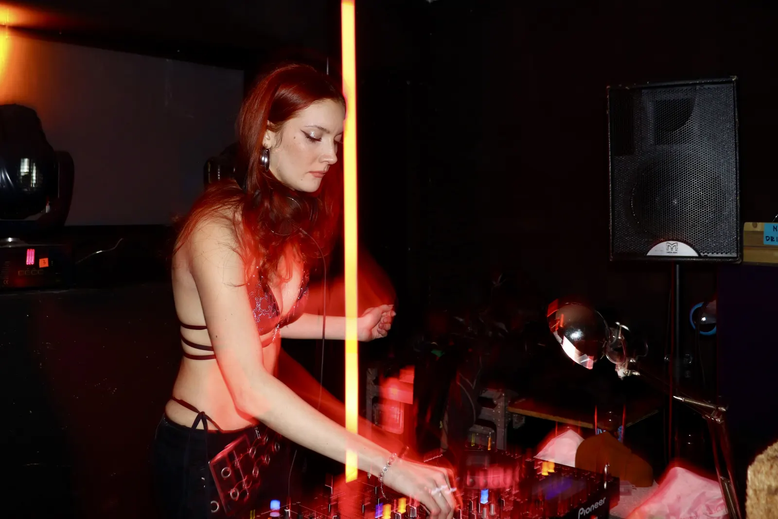 DJ framed by red light in the club room