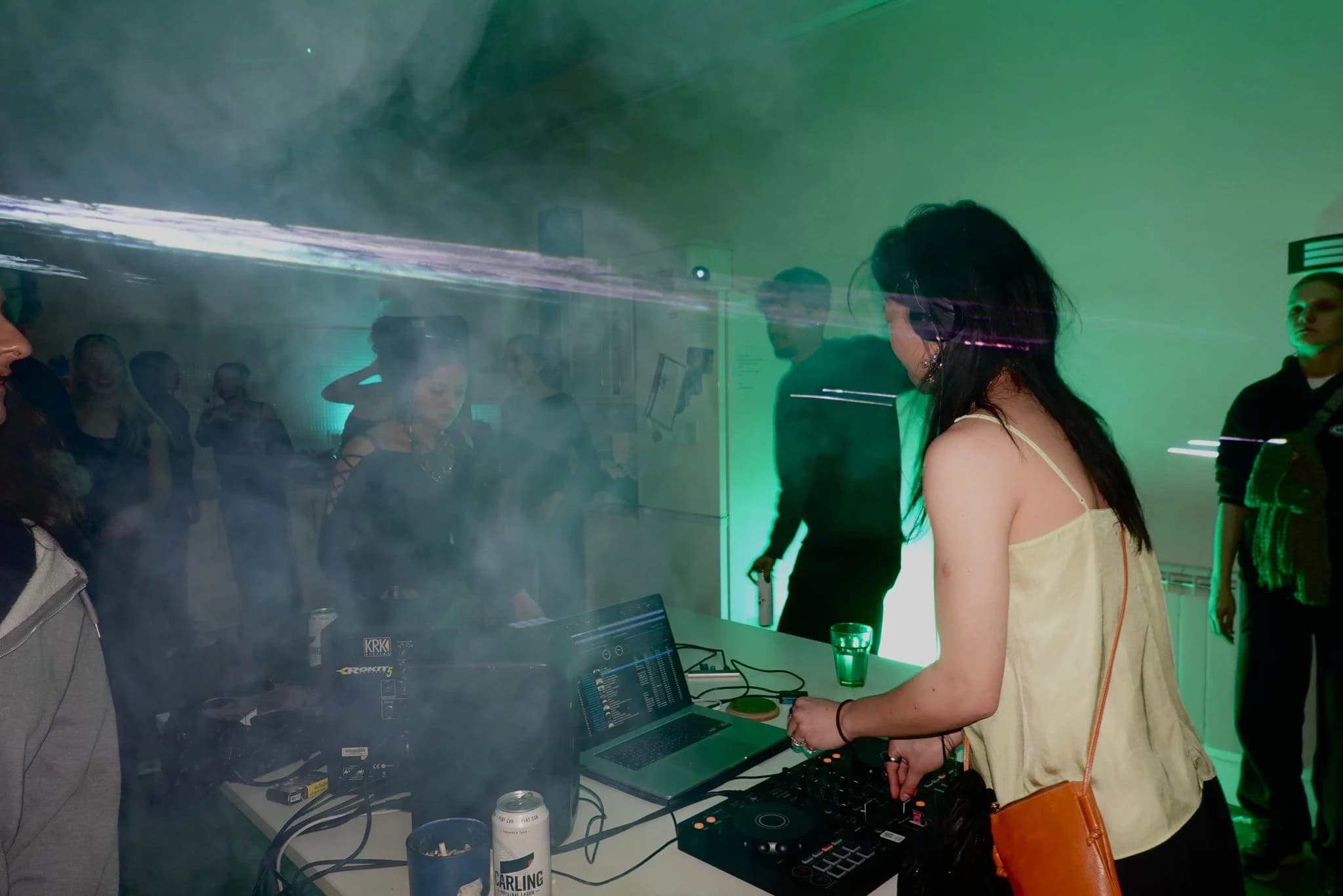 DJ playing through smoke and green light at Requiem